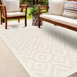 Outdoor patio scene with wood furniture and Burl Cream Outdoor Rug, featuring a geometric pattern. Roomscene-Rectangle
