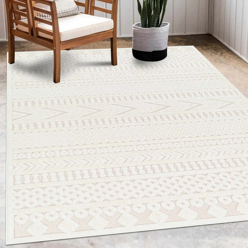 Living room scene with a Southwestern Jove Cream Outdoor Rug, wood chair, and potted snake plant. Roomscene-Rectangle