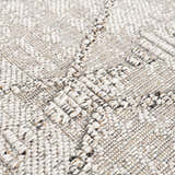 Close-up of the Nyla Bone Indoor Outdoor Rug, showing woven texture and geometric pattern in neutral bone tones. Texture