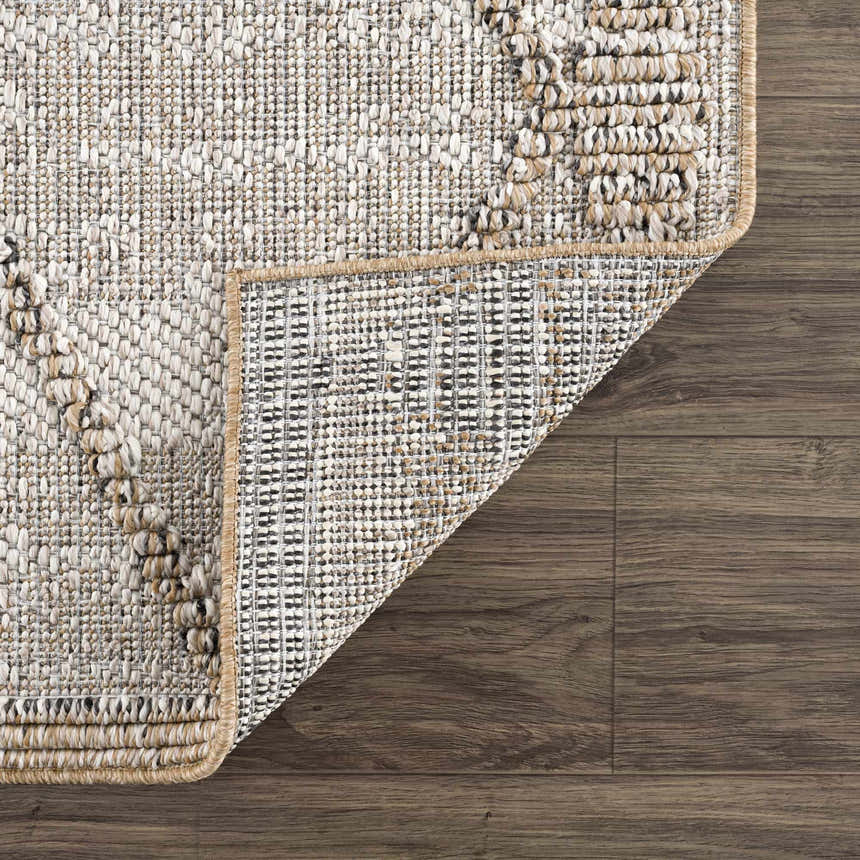 Close-up of the Nyla Bone & Tan Textured Performance Rug showing woven detail and construction. Fold