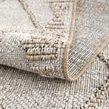 Close-up of the textured Nyla Bone & Tan Performance Rug, showing the woven design and neutral color palette. Fold