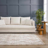 Living room scene with a Nyla Bone & Tan rug, cream sofa, wood side tables, and blue accent wall. Roomscene-Rectangle