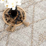 Close-up of the Nyla Bone & Tan Textured Performance Rug, a farmhouse style rug with a woven design. Styleshot