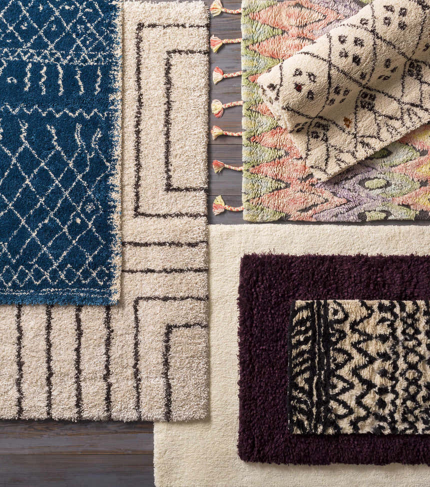 Assorted Duncanville Area Carpet samples: plum, blue, and neutral tones. Hand-woven wool rugs with contemporary patterns and textures. Styleshot