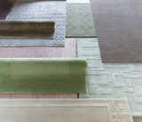 Assorted clearance rugs, including a dusty pink Millinocket Area Rug, showing various textures, colors, and patterns. Styleshot