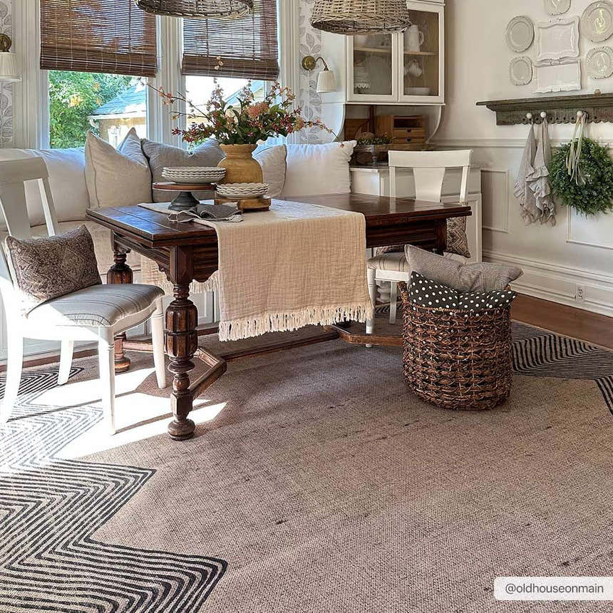 Farmhouse dining room with a Suzy Washable Jutely Rug, dark wood table, and neutral accents. Roomscene-Rectangle