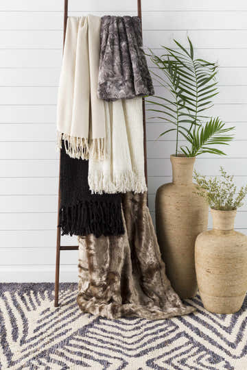 Styled Bradshaw Clearance Jute Rug in a farmhouse setting with blankets on a ladder and jute vases. Styleshot