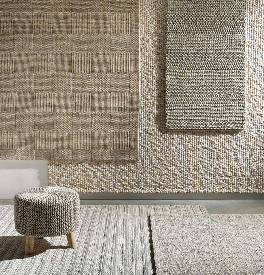 Textured rug display featuring the Yarrabilba Area Rug, showcasing hand-woven designs in ivory, charcoal, and off-white hues. Texture