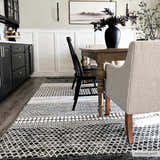Dining room with black cabinets and Tideswell Scandi Boho Wool Carpet in beige and black under a wooden table. Roomscene-Rectangle