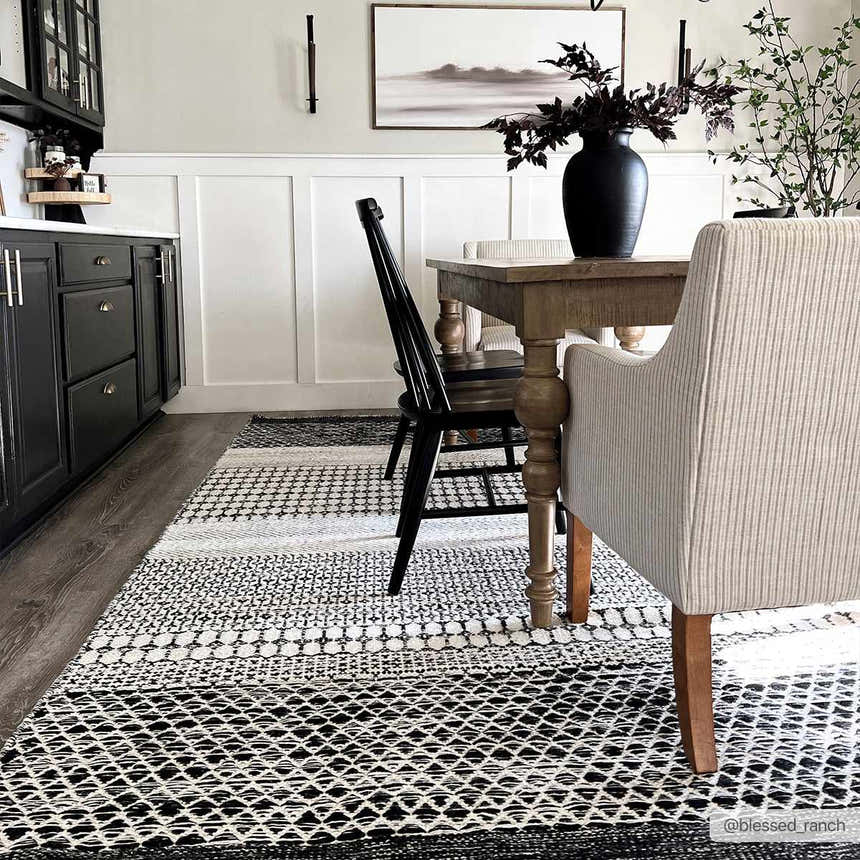 Dining room with black cabinets and Tideswell Scandi Boho Wool Carpet in beige and black under a wooden table. Roomscene-Rectangle