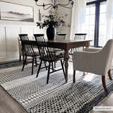Dining room with a Tideswell Scandi Boho Wool Carpet, wood table, black chairs, and neutral walls. Roomscene-Rectangle