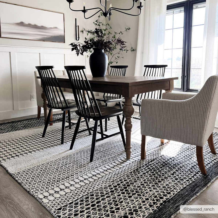 Dining room with a Tideswell Scandi Boho Wool Carpet, wood table, black chairs, and neutral walls. Roomscene-Rectangle