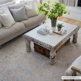 Living room scene with a neutral sofa and the Tinampo Area Rug in brick red, cream, and denim. Farmhouse style coffee table. Roomscene-Rectangle