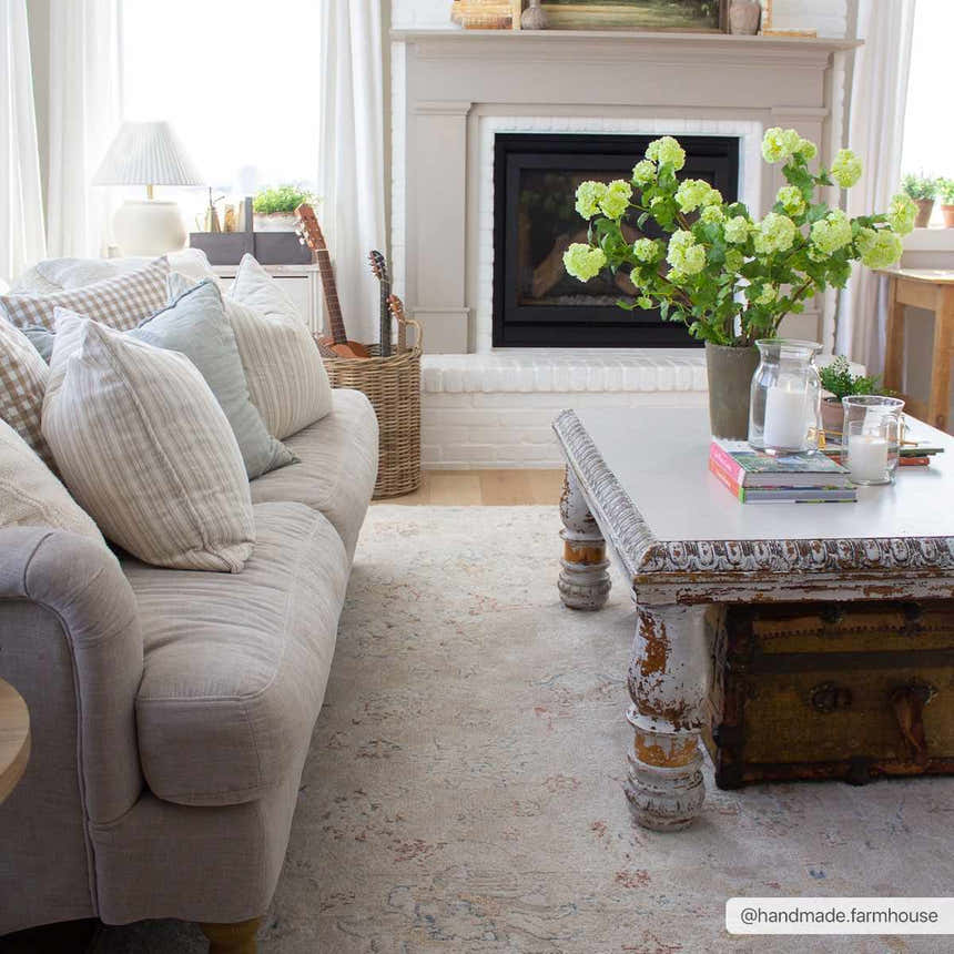 Farmhouse living room with a Tinampo Area Rug, linen sofa, white coffee table, and brick fireplace. Roomscene-Rectangle