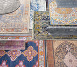 Overhead shot of assorted Astatula Area Rugs in blue, ivory, gray, and orange with bohemian, farmhouse, and traditional patterns. Styleshot