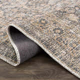 Close-up of the Orsin Washable Area Rug showing its farmhouse traditional design, neutral colors, and textured weave. Fold