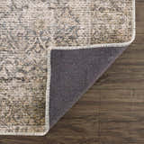 Close-up of the Ohoud Washable Area Rug showing its neutral beige, brown, and gray traditional pattern and non-slip backing. Fold