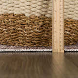 Close-up of the Ohoud Washable Area Rug showing its low pile, neutral colors, and woven edge detail with a measuring ruler. Pile