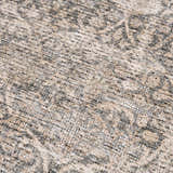 Close-up of the Ohoud Washable Area Rug showing its beige, cream, and gray traditional pattern and textured weave. Texture