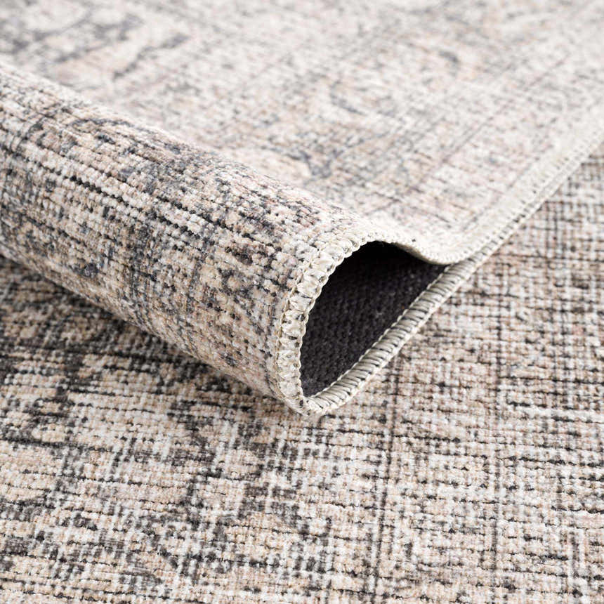 Close up of the Odele Washable Area Rug in medium gray, showing the chenille polyester texture and machine-woven construction. Fold