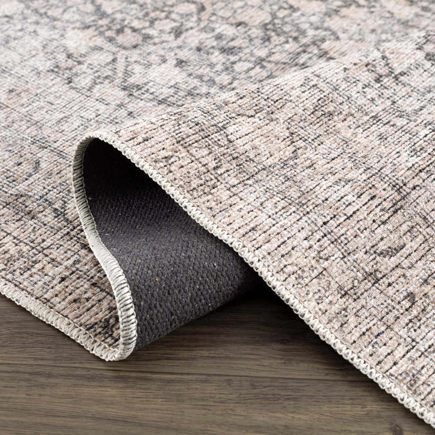 Close-up of the Odele Washable Area Rug in medium gray. Chenille polyester and cotton rug with a traditional pattern. Fold