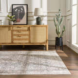 Living room scene with a gray Odele Washable Area Rug, wood floors, and a natural wood cabinet with decor. Roomscene-Rectangle
