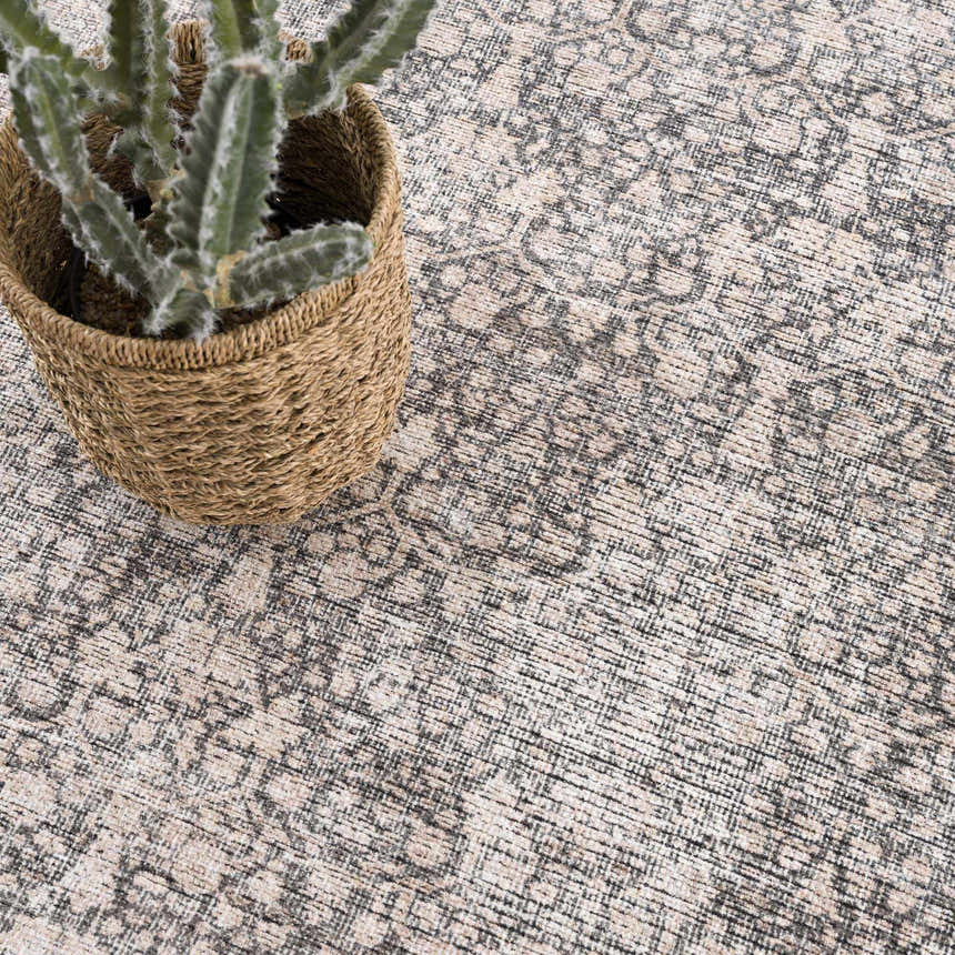 Close-up of the Odele Washable Area Rug in medium gray, featuring a traditional, subtly distressed pattern and soft texture. Styleshot