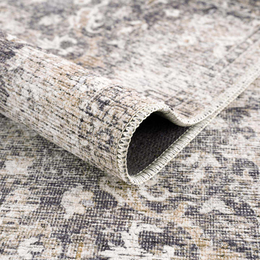 Close-up of the Mohan Washable Area Rug showing its farmhouse style, traditional pattern, and chenille polyester texture. Fold
