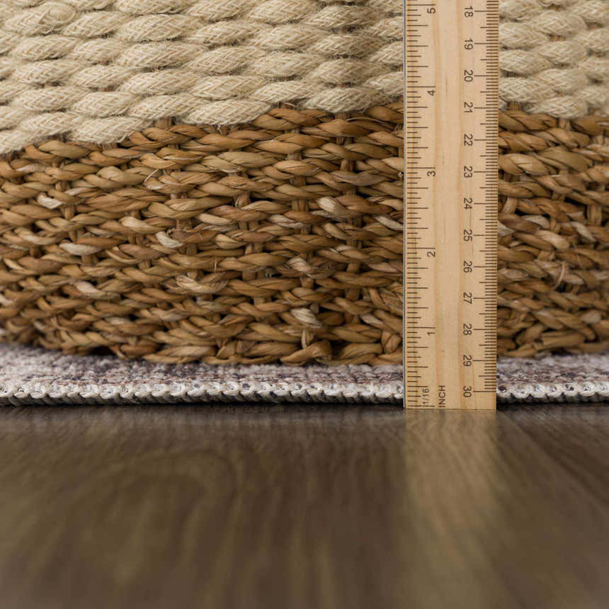 Close up of the Mohan Washable Area Rug showing the edge and pile height with a ruler. Pile