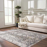Living room scene with a neutral sofa and the Mohan Washable Area Rug in gray, beige, and navy tones on dark wood floors. Roomscene-Rectangle