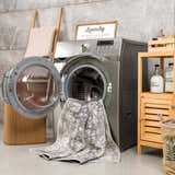 Laundry room scene with a gray washing machine and the Mohan Washable Area Rug draped from the open door. Washing-Machine
