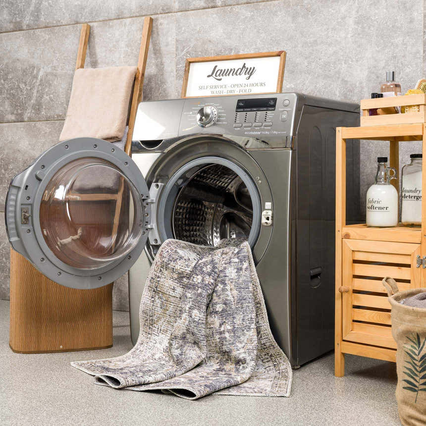 Laundry room scene with a gray washing machine and the Mohan Washable Area Rug draped from the open door. Washing-Machine