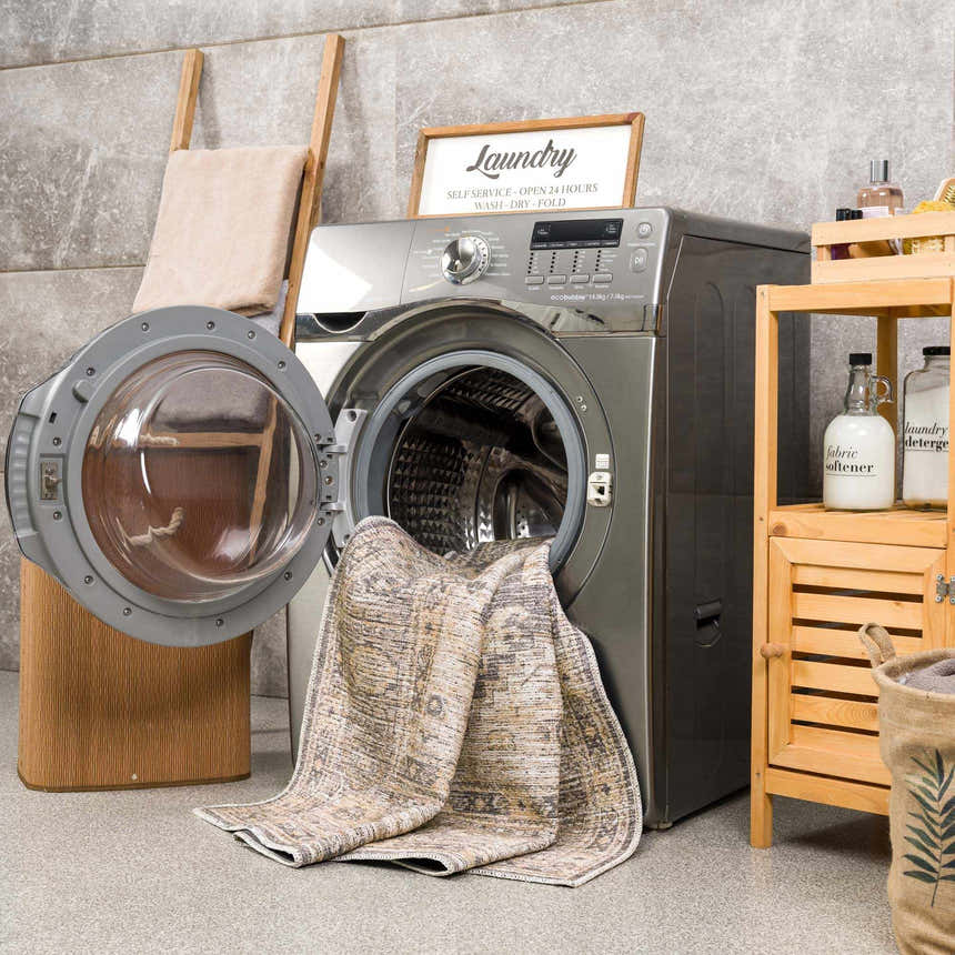 Keola Washable Area Rug in a laundry room with a washing machine and wooden shelving. Farmhouse style. Washing-Machine