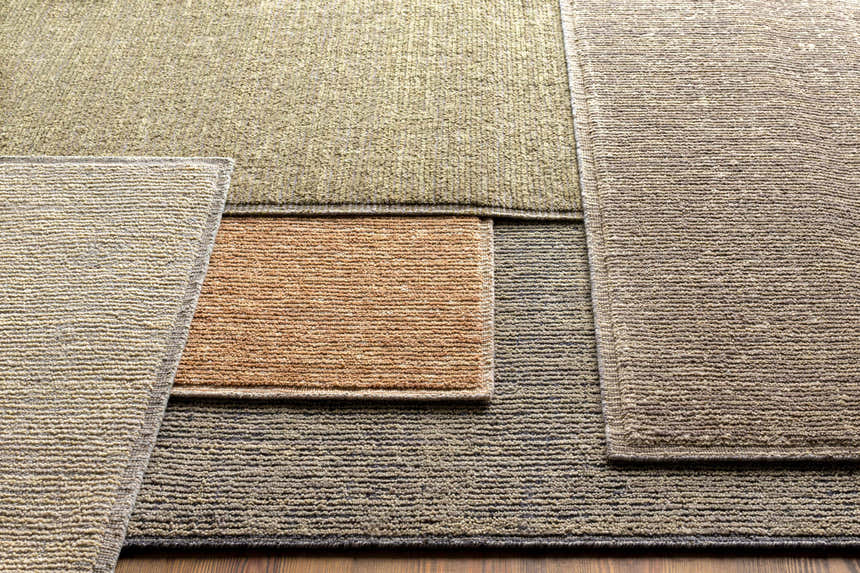 Close-up of textured Magpet Area Rug. Colors include charcoal, light beige, and olive. Hand-loomed 100% wool rug. Styleshot
