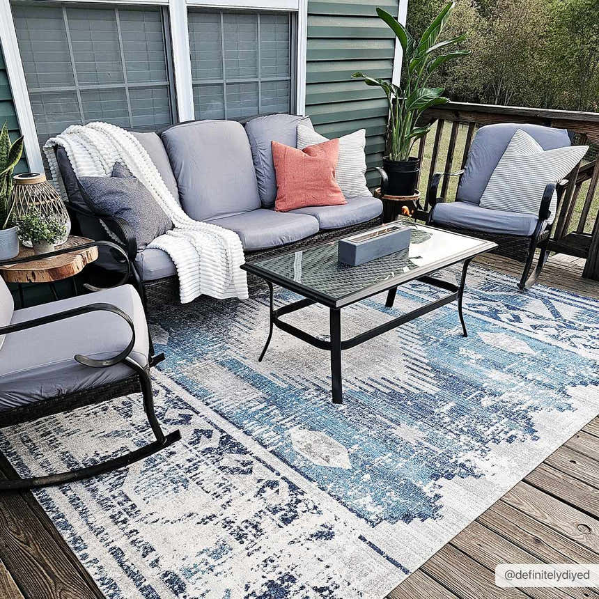 Outdoor patio scene with gray furniture and the Westmount Denim Aztec Area Rug in blue and cream. Roomscene-Rectangle