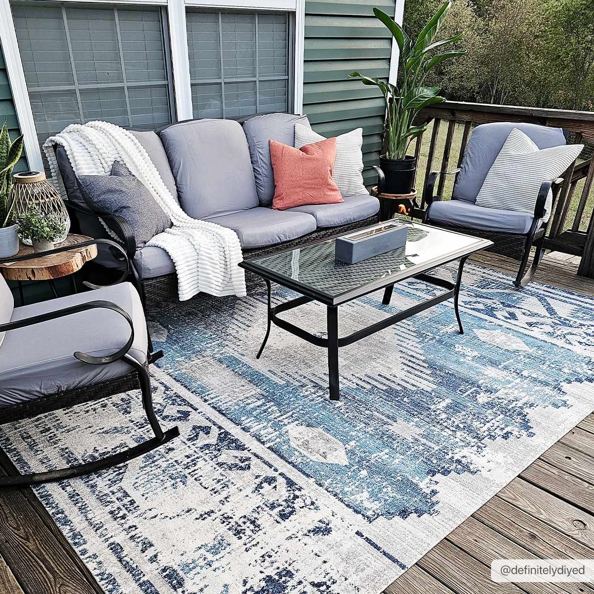 Outdoor patio scene with gray furniture and the Westmount Denim Aztec Area Rug in blue and cream. Roomscene-Rectangle