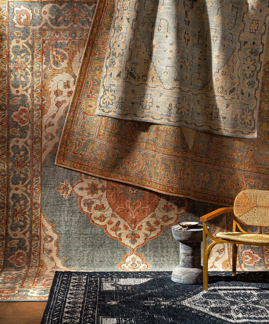 Stacked Minapan Premium Area Rugs in black, cream, and blue, with traditional oriental patterns and a woven chair. Styleshot