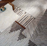Close-up of the Wauzeka Premium Area Rug. Hand-crafted hair on hide rug with brown, cream, gray, and red tones. Contemporary style. Styleshot