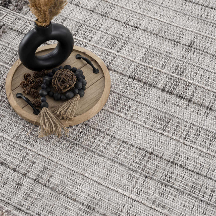 Close-up of the Naivasha Elegant High/Low Area Rug. Charcoal, cream, and gray textured rug with a modern, bohemian design. Styleshot