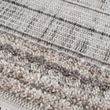 Close-up of the Naivasha Elegant High/Low Area Rug. Features charcoal, cream, and gray tones with a textured, high-low pile. Texture
