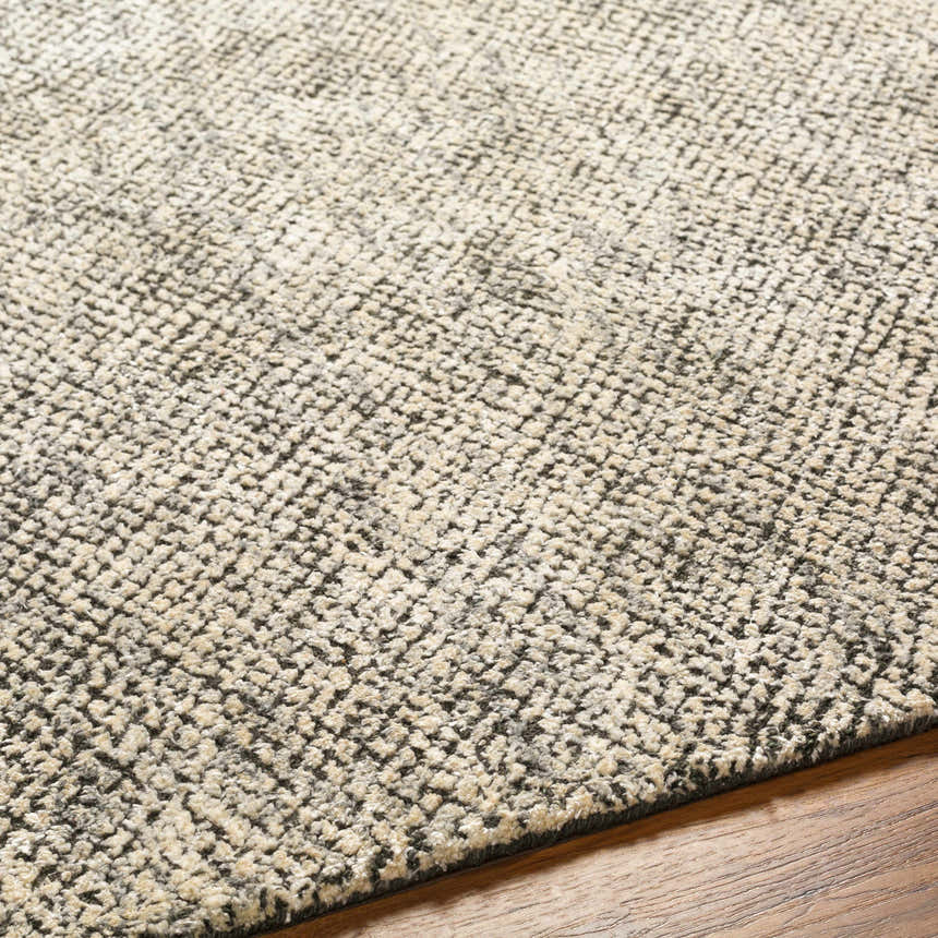 Close-up of the hand-loomed Abiba Area Rug, a contemporary design in beige, black, and taupe, with a textured wool and viscose blend. Texture
