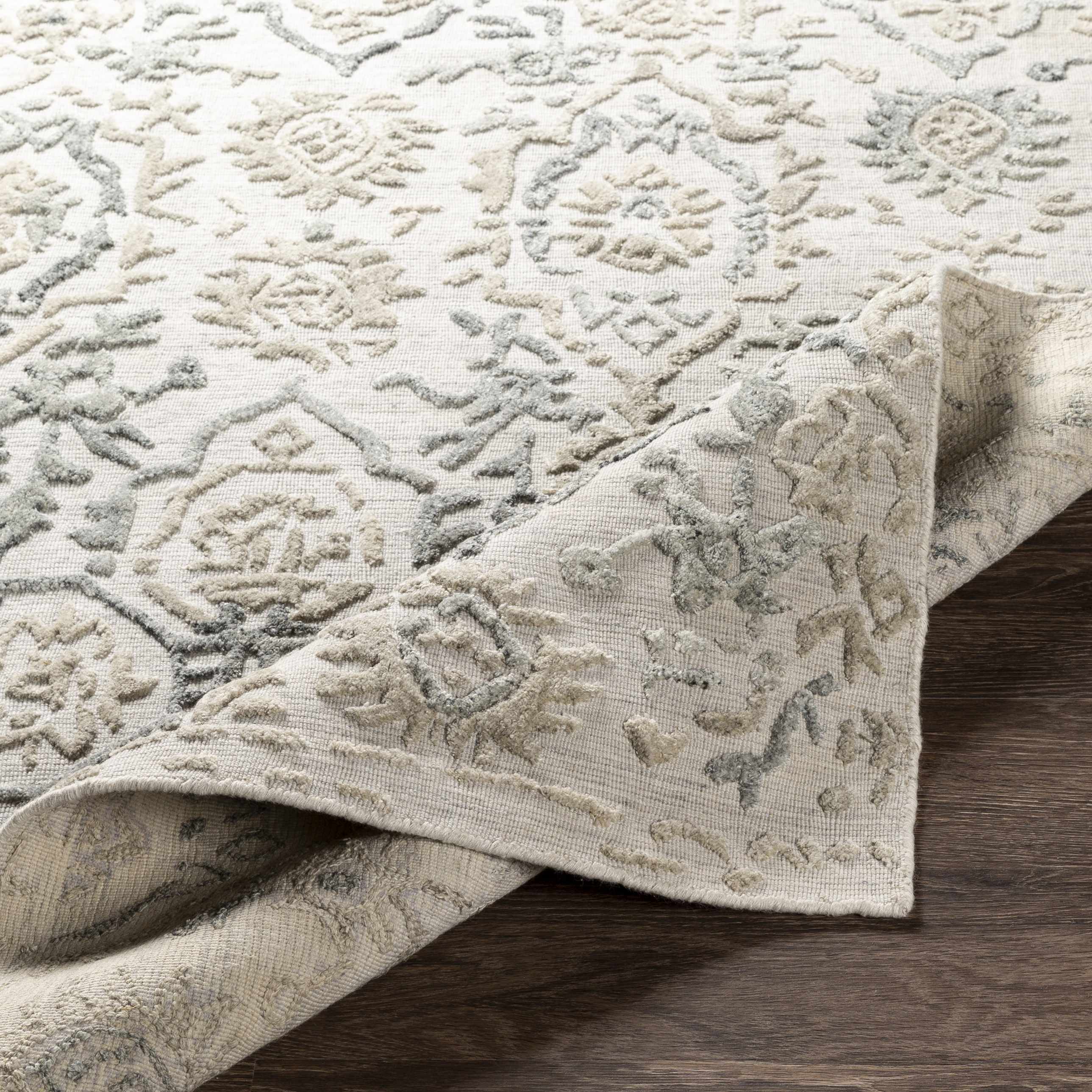 Folded section of Acle Area Rug - Clearance, displaying material thickness and weave. Traditional Area Rug Backing  