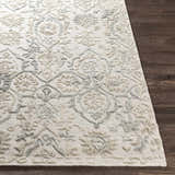 Close-up of the Acle Area Rug showing its raised, textured floral and geometric pattern in cream, beige, and gray. Front