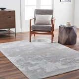 Living room scene with a gray Adwoa Boutique Rug, gray chair, wood accents, and modern decor for a contemporary feel. Roomscene-Rectangle