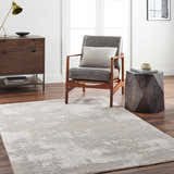 Living room scene with a gray Adwoa Boutique Rug, leather chair, wood side table, and dresser on dark wood floors. Roomscene-Rectangle