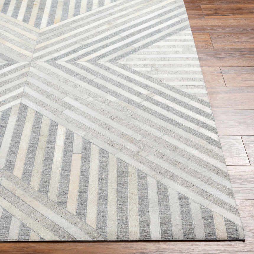 Close-up of Akiye Area Rug. Beige, cream, and gray geometric pattern on a hand-crafted leather and viscose rug. Front