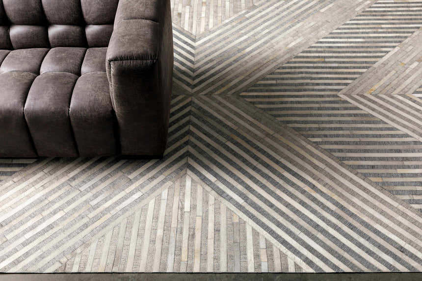Living room scene with a gray sofa on the Akiye Area Rug, a geometric rug in beige, cream, and gray. Styleshot