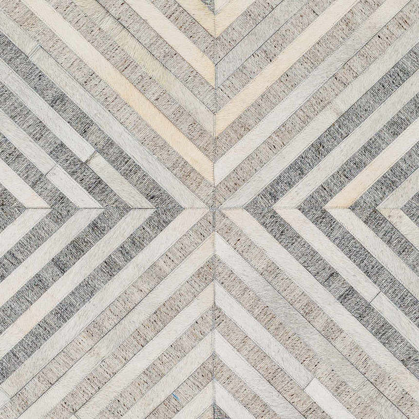 Close-up of the Akiye Area Rug showcasing its geometric pattern in beige, cream, and gray leather and viscose. Swatch