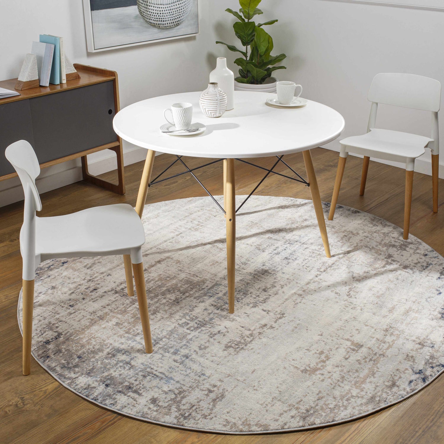 Dining room scene with a round white table on a blue and gray Alcove Abstract Area Rug. Roomscene-Round