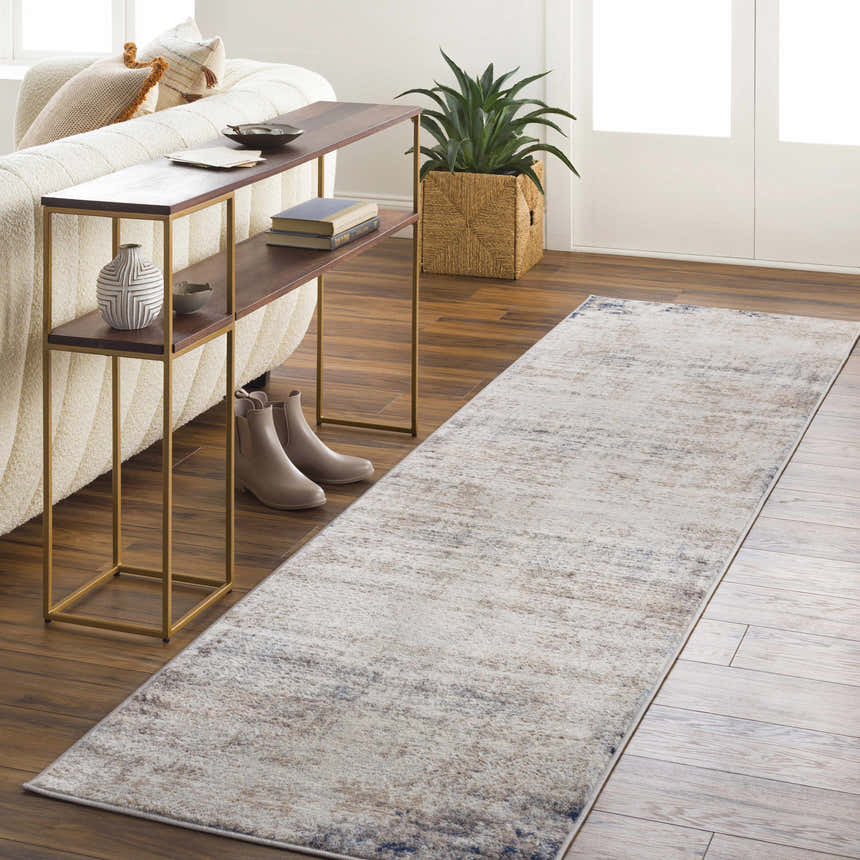 Living room scene with Alcove Abstract Area Rug runner in light gray, ivory, and blue. Styled with console table, plant, and sofa. Roomscene-Runner